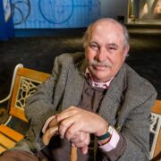 Portrait of historian and author John V. Quarstein sitting on a bench inside The Mariners' Museum.