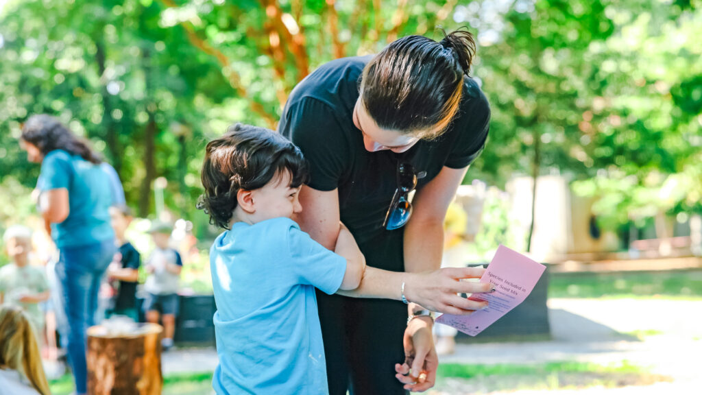 Child hugging the arm of their parent.