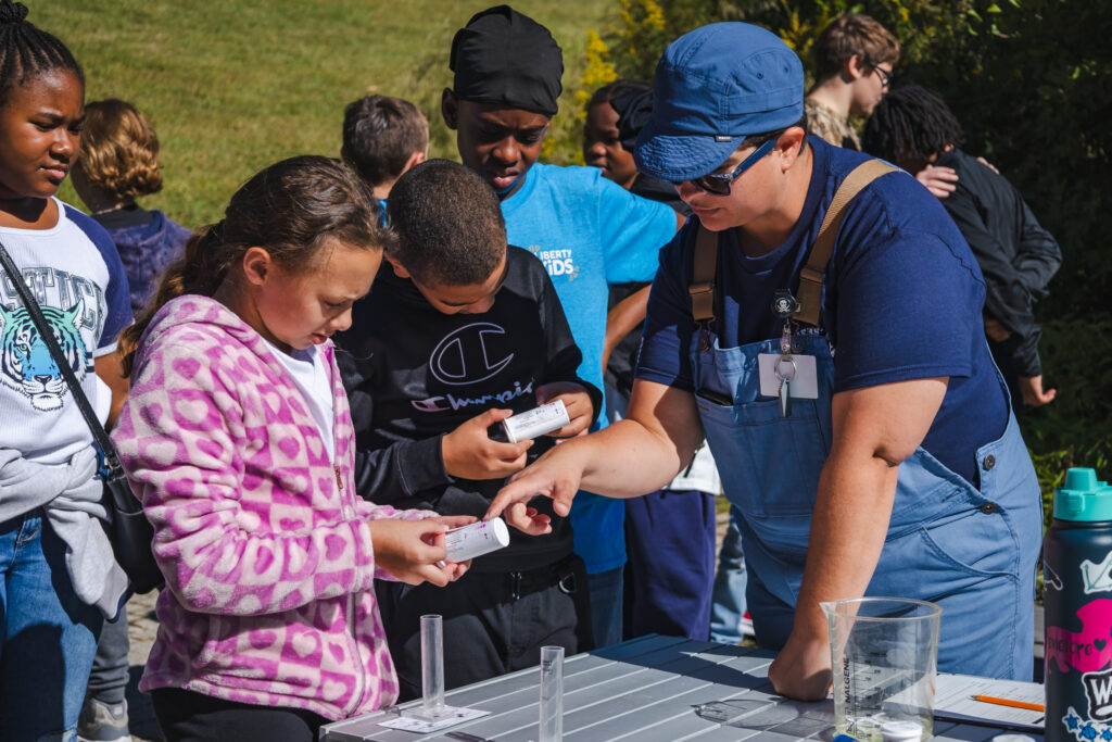 Educator showing the students how to read a water quality test.