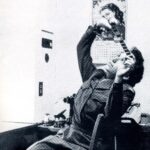 A woman in uniform observes a film strip.