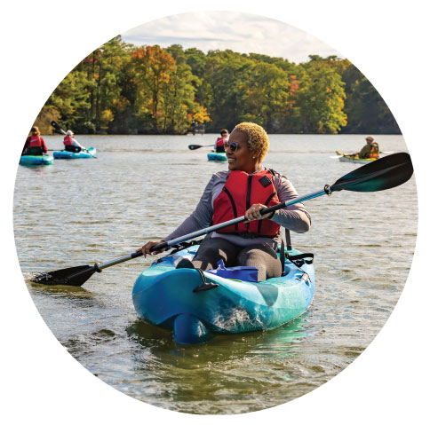 African American lady in a blue kayak on the lake