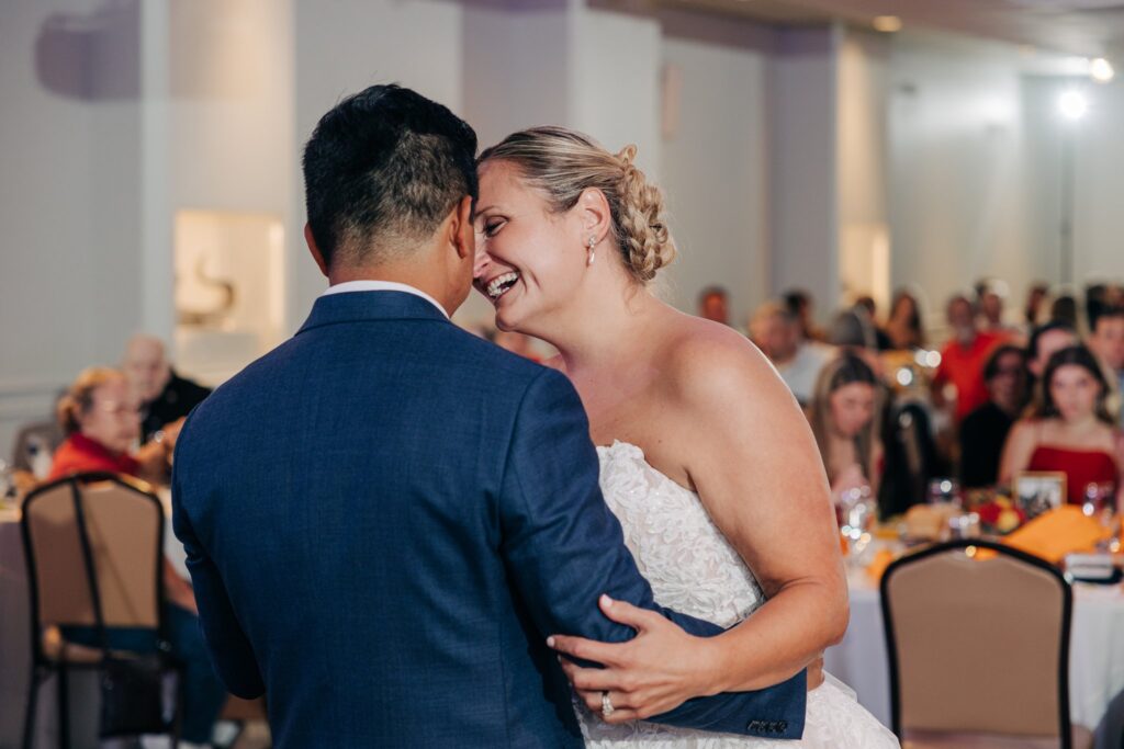 Bride smiling at groom while dancing together.