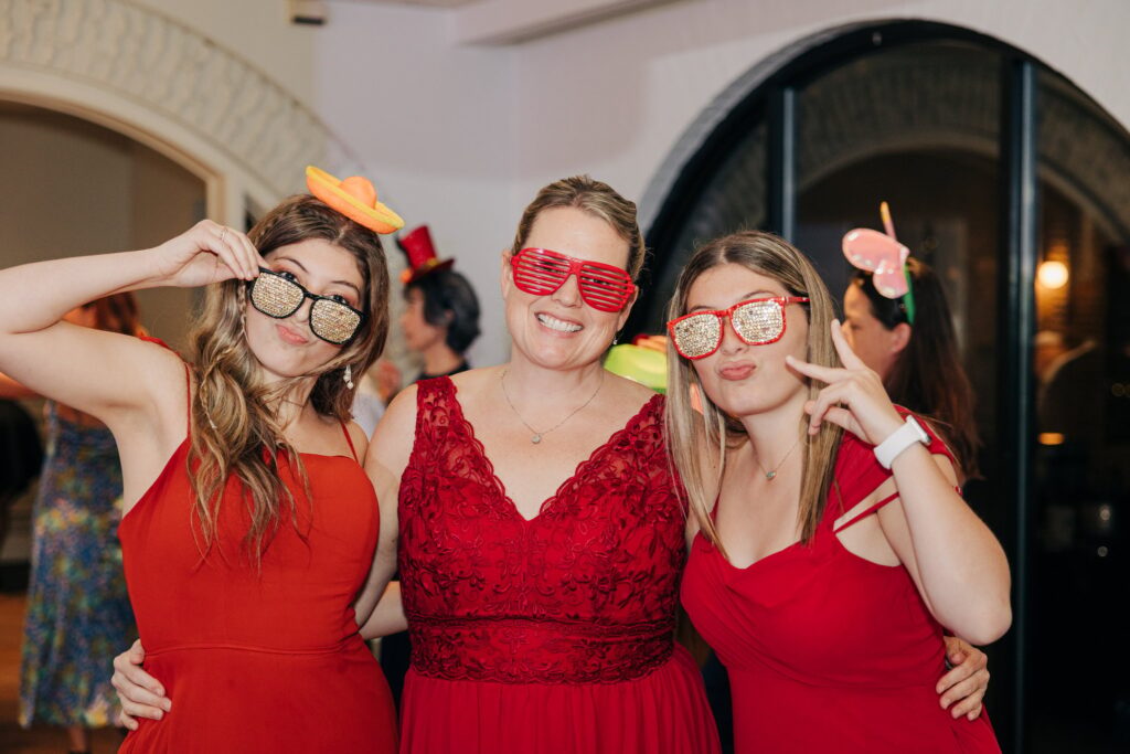 Fun photo of wedding guests in sunglasses and little hats.