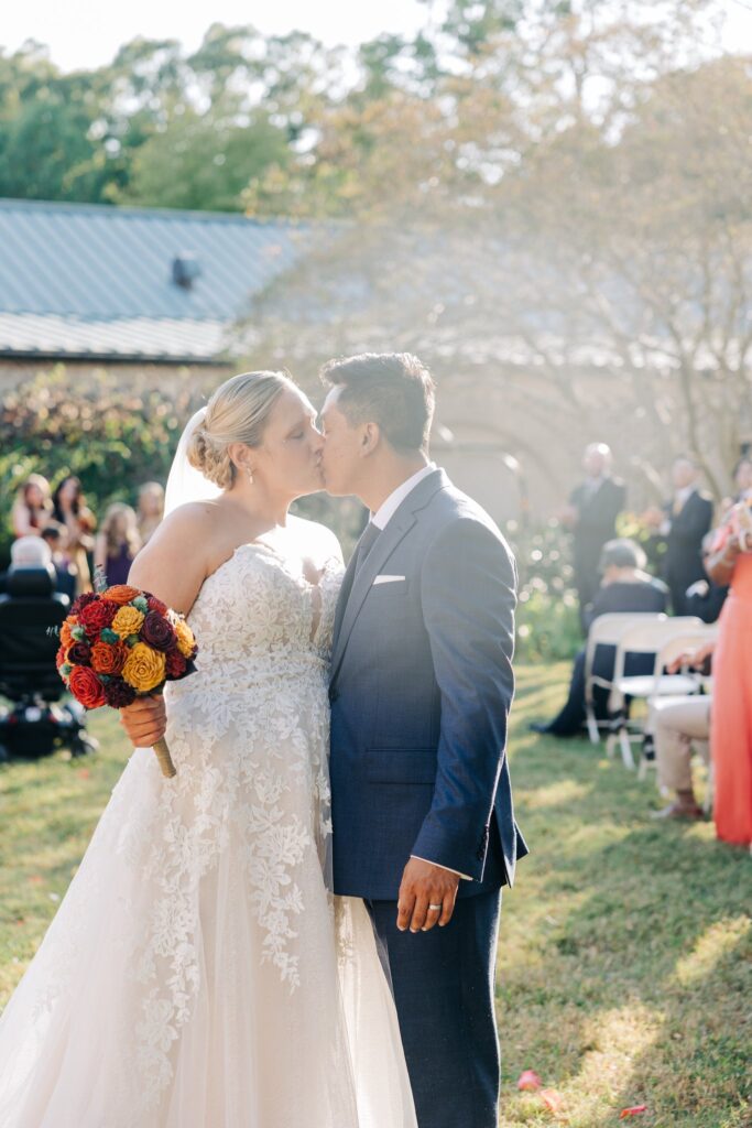 Bride and groom kissing while walking back from the altar.